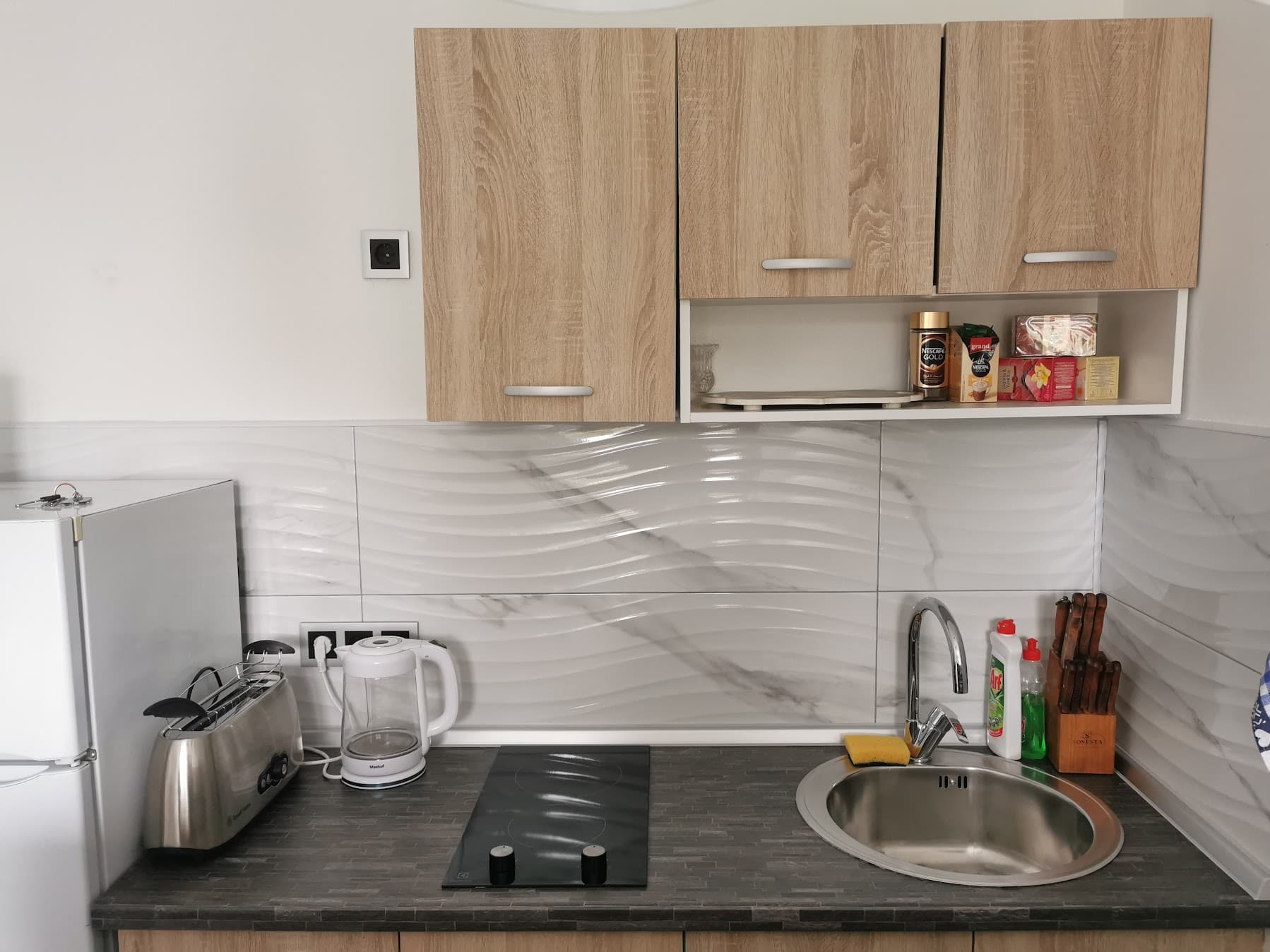 Kitchenette with stove, sink, and cabinets